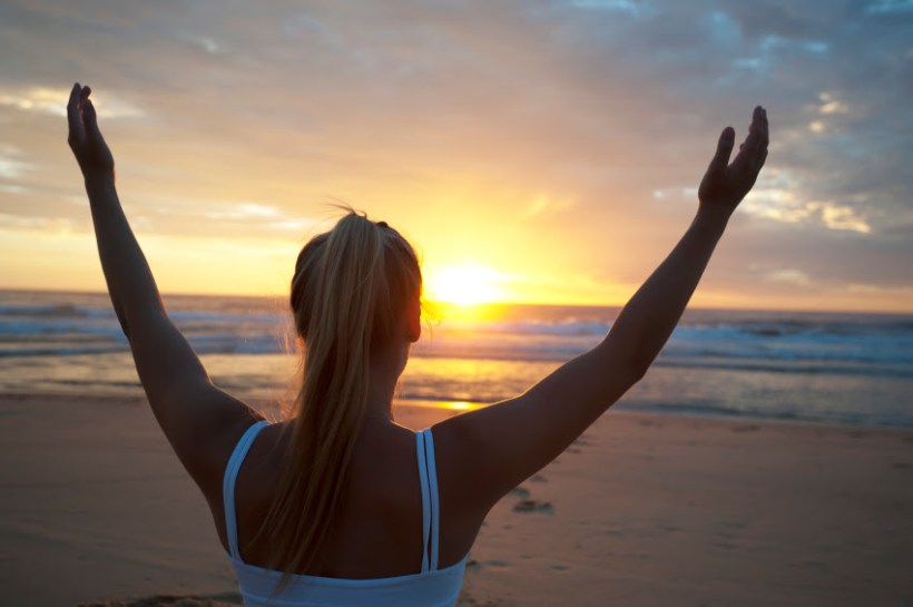 Woman doing yoga on the beach